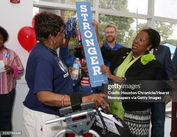 Congresswoman Sheila Jackson Lee, right, hands a "Stronger Together" slogan plaque to Dorothea S. Pindell, a precinct chair of precinct 0338, at the...