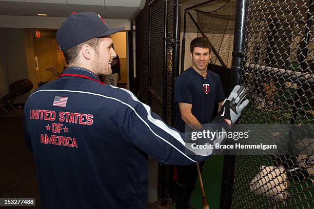 Kevin Love of the Minnesota Timberwolves talks with Joe Mauer of the Minnesota Twins while touring the clubhouse prior to the game against the New...