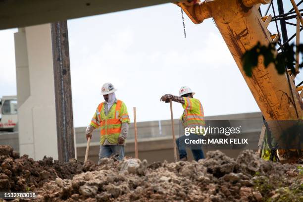 Construction workers rebuild the I-69 Southwest/I-610 West Loop Interchange during a heat wave in Houston, Texas, on July 14, 2023. Climate...