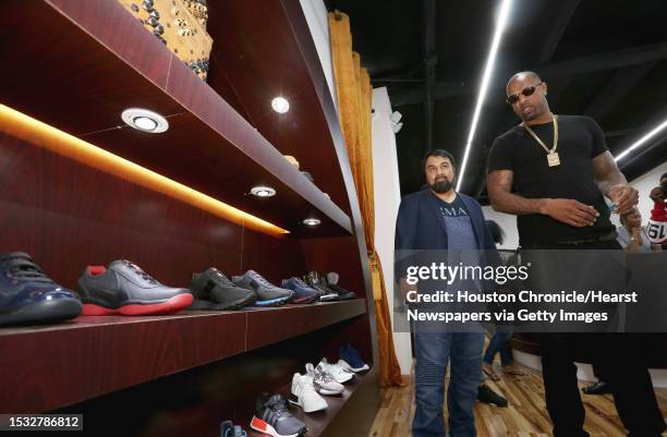 Rapper Slim Thug goes through the commodities at Paul Wall's grillz store, Johnny Dang & Co., Saturday, Oct. 22 in Houston.