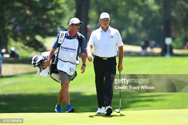 Retief Goosen of South Africa walks down the fairway with his caddie, Jeff Johnson, during the second round of the Kaulig Companies Championship at...