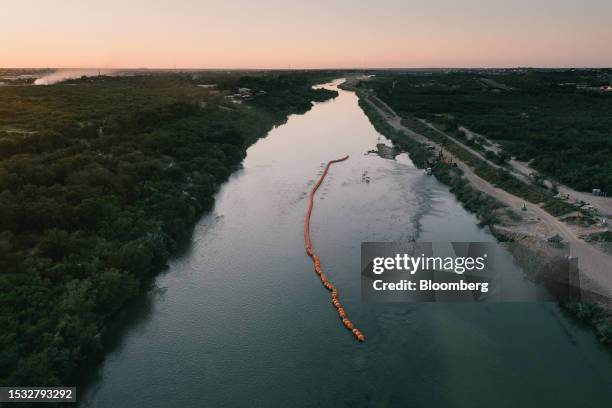 String of buoys used as a border barrier on the Rio Grande River in Eagle Pass, Texas, US, on Thursday, July 13, 2023. Texas started deploying a new...