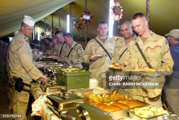 Troops are served Thanksgiving dinner 28 November 2002 at Camp New York in the Kuwaiti desert, about 45kms south of the eastern border with Iraq....