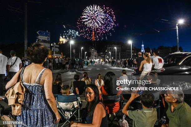 People watch fireworks explode over the Basilica Notre-Dame of Fourviere as part of the annual Bastille Day celebrations in Lyon, on July 14, 2023.