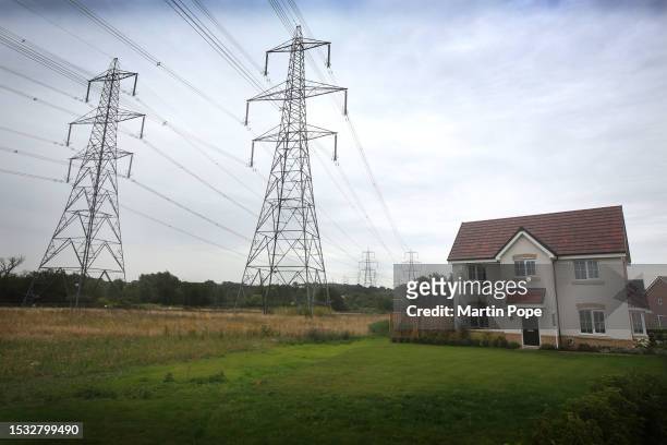 Existing pylons crossing the Suffolk countryside in close proximity to a new housing development on July 14, 2023 in Bramford, United Kingdom. The...