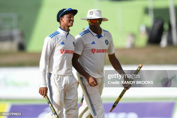 Yashasvi Jaiswal and Ravichandran Ashwin of India with stumps after winning on day three of the First Test between West Indies and India at Windsor...