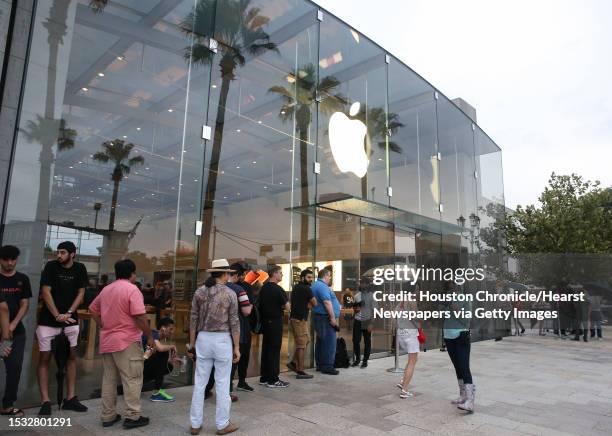 Apple customers wait in the line and ready to purchase the new products at the Highland Village Apple store before the doors open at 8 a.m. On...