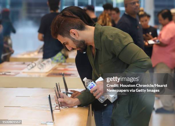 Apple customers shop in the Highland Village Apple store to purchase the new products as the doors opened at 8 a.m. On Friday, Sept. 21 in Houston....