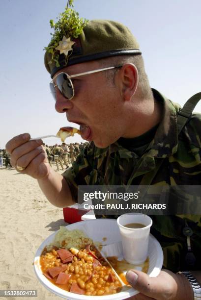 British Army Irish Guard Lance Sgt. Graeme Day, from Rochford, Essex, and serving with the, 7th Armored Brigade has some beans for breakfast 17 March...