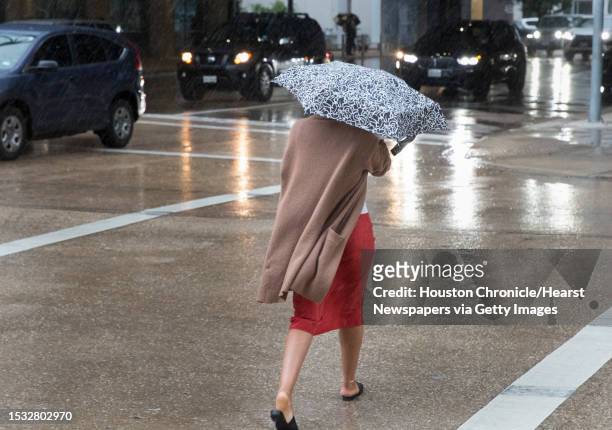 Pedestrian holds on to the umbrella while crossing Fanning and Polk Streets as Tropical Storm Imelda is making its way across the Houston area during...