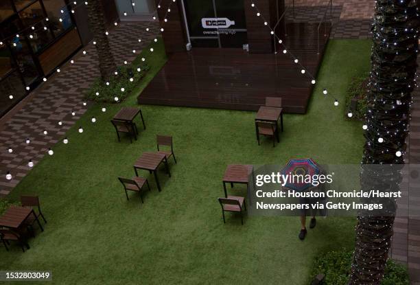 Pedestrian use walks through the patio area of the GreenStreet as Tropical Storm Imelda is making its way across the Houston area during rush hour on...