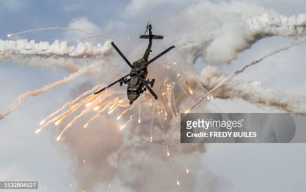Colombian Air Force pilots on their Sikorsky UH-60 Black Hawk helicopters perform acrobatics during the F-Air Colombia 2023 air festival in Rionegro,...