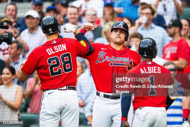 Austin Riley of the Atlanta Braves congratulates Matt Olson after he hit a grand slam during the first inning against the Chicago White Sox at Truist...