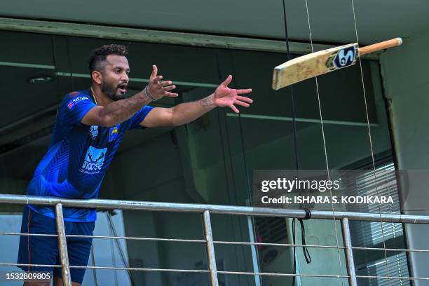 Sri Lanka's captain Dimuth Karunarathna throws a bat to a teammate during a practice session at the Galle International Cricket Stadium in Galle on...