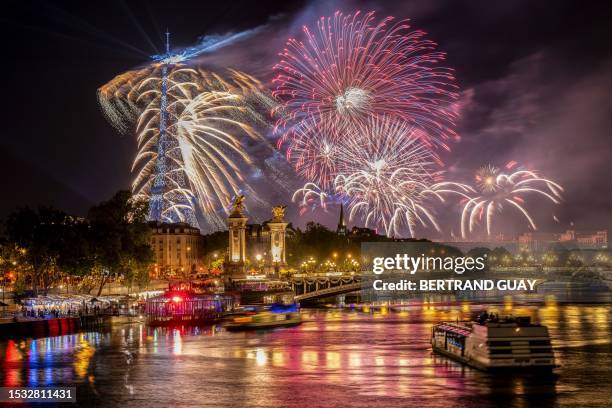 Fireworks explode next to the Eiffel Tower and the Seine river as part of the annual Bastille Day celebrations in Paris, on July 14, 2023.