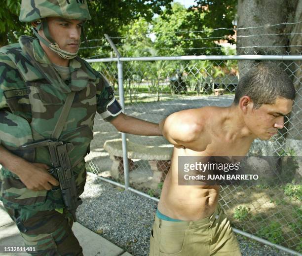 Venezuelan soldier guarda an alleged Colombian paramilitary militant, in Caracas, after his arrest in Daktari farm, east of the capital 09 May 2004....