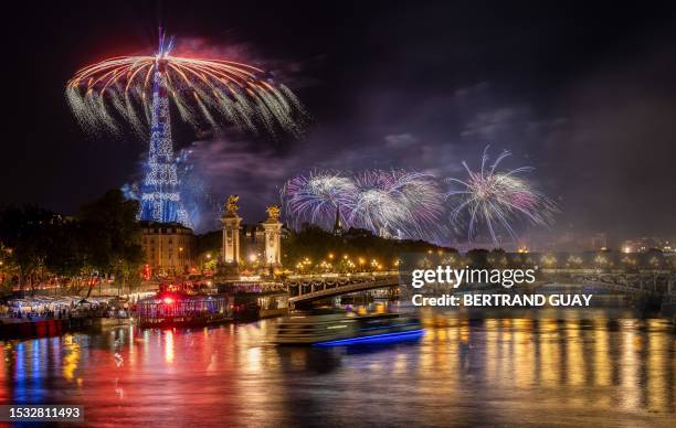 Fireworks explode next to the Eiffel Tower and the Seine river as part of the annual Bastille Day celebrations in Paris, on July 14, 2023.