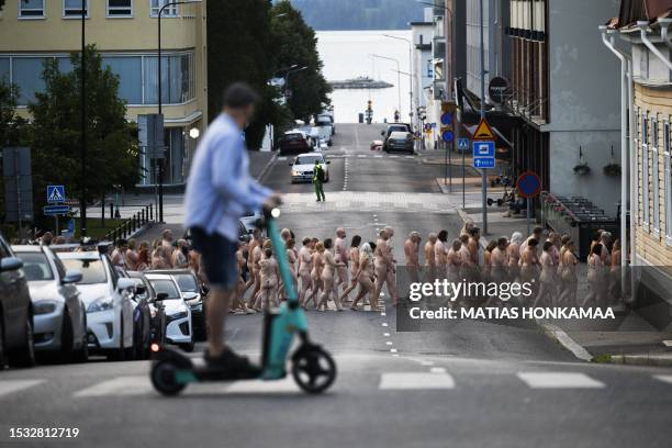 Graphic content / Volunteers move from the first photo shooting spot towards another as they pose nude for US art photographer Spencer Tunick in...