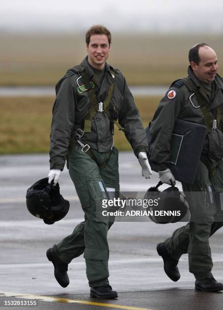 Prince William walks across the airfield with instructor Squadron Leader Roger Bousfield to board his training aircraft while training at airbase RAF...