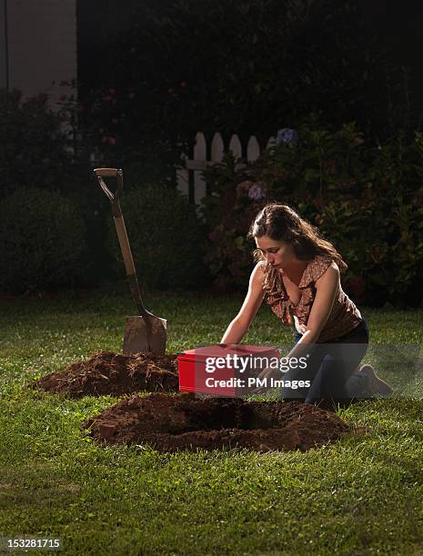 young woman burying red box - bury fotografías e imágenes de stock