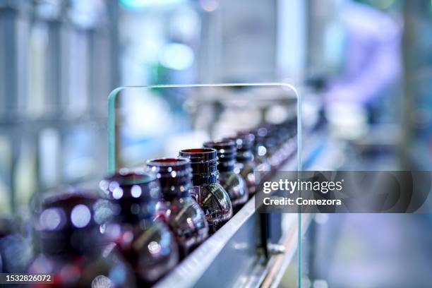 medicine brown glass bottles at production line - farmaceutische-fabriek stockfoto's en -beelden