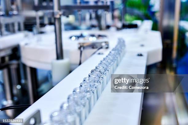 medicine transparent vials at production line - vaccine manufacturing stock pictures, royalty-free photos & images
