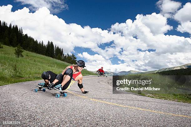 two longboarders taking a sharp turn. - woman longboard stock pictures, royalty-free photos & images