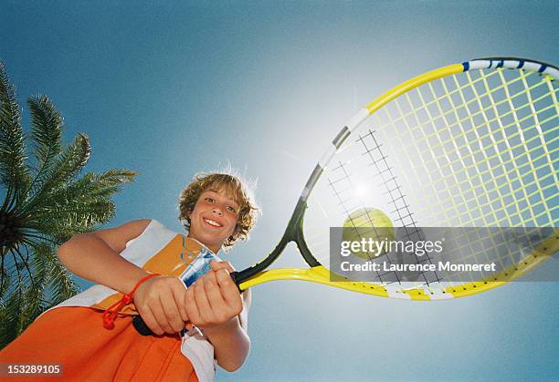 smiling boy with tennis racket and ball - tennis boy stock pictures, royalty-free photos & images