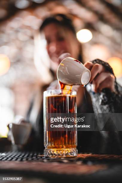 female barista making iced americano coffee - americano stockfoto's en -beelden