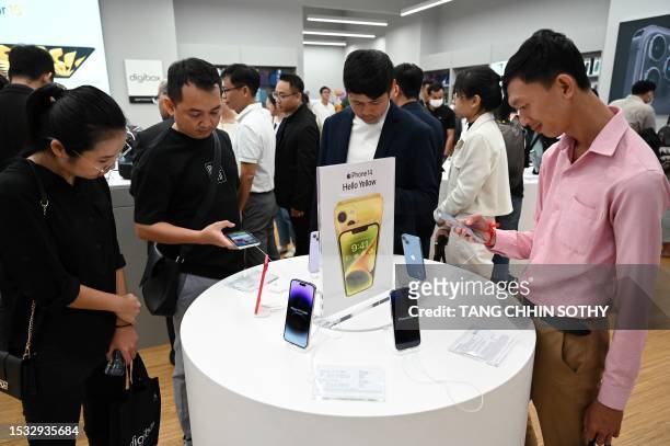 People look at series's iPhone 14 during the first Apple Premium Reseller grand opening in Phnom Penh on July 15, 2023