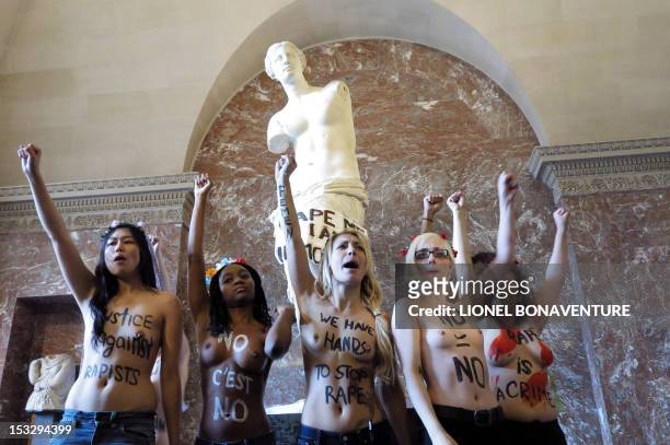 Topless activists of the Ukrainian women movement Femen protest against anti women's politic in front of the Venus de Milo statue where they hung a...