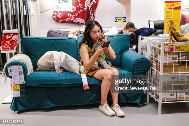 Woman sits on a sofa with her dog in an Ikea store on July 15, 2023 in Hong Kong, China.