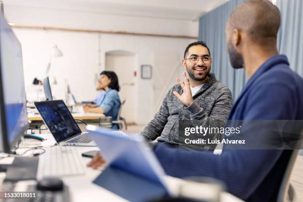 young software developers discussing code while working in coworking office - web designer fotografías e imágenes de stock