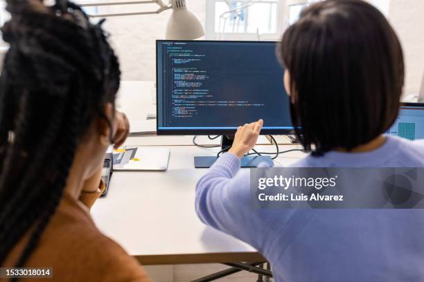 team of developers working on new software program on computer - über die schulter stock-fotos und bilder
