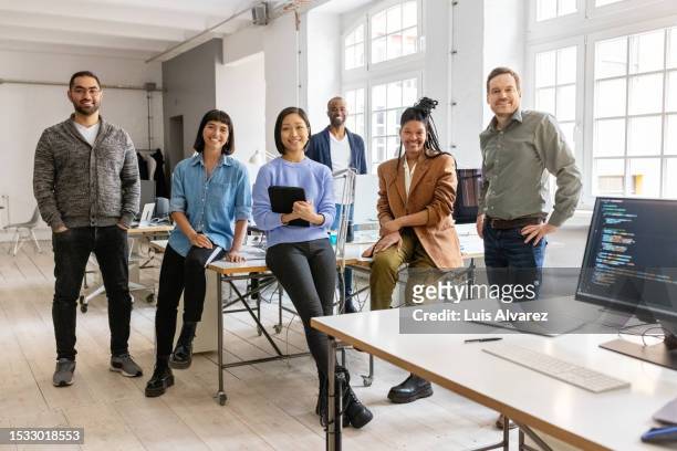 portrait of a happy multiracial business group together in a creative office - japanese ethnicity stock pictures, royalty-free photos & images
