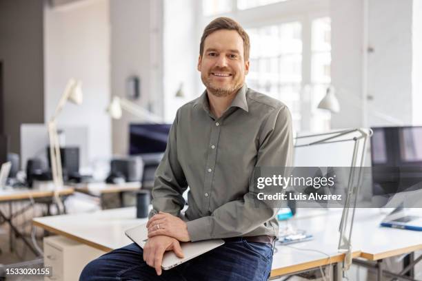 happy mid adult businessman in startup office - generaldirektor fachberuf stock-fotos und bilder