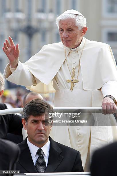Pope Benedict XVI flanked by his new butler Sandro Mariotti arrives on popemobile in St. Peter's square for his weekly audience on October 3, 2012 in...