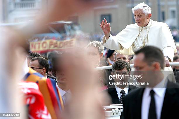 Pope Benedict XVI flanked by his new butler Sandro Mariotti arrives on popemobile in St. Peter's square for his weekly audience on October 3, 2012 in...