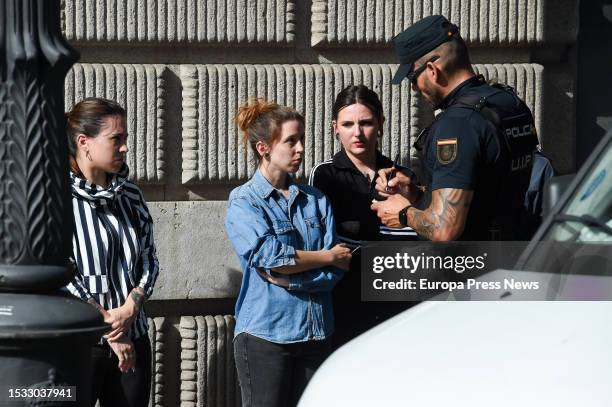 National Police officer asks for documentation to Femen activists who have protested under the slogan 'Falange legal, national shame', in front of...