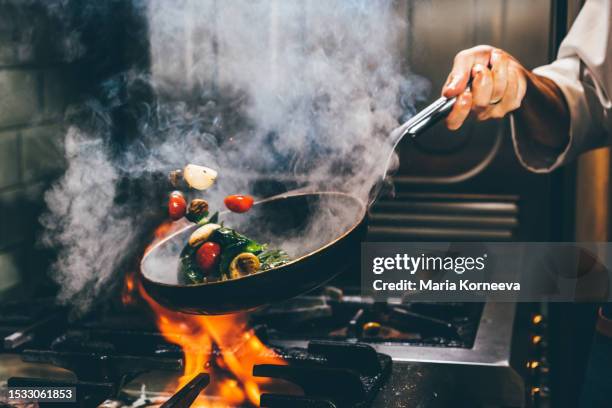 chef frying vegetables in a pan. - wok stockfoto's en -beelden