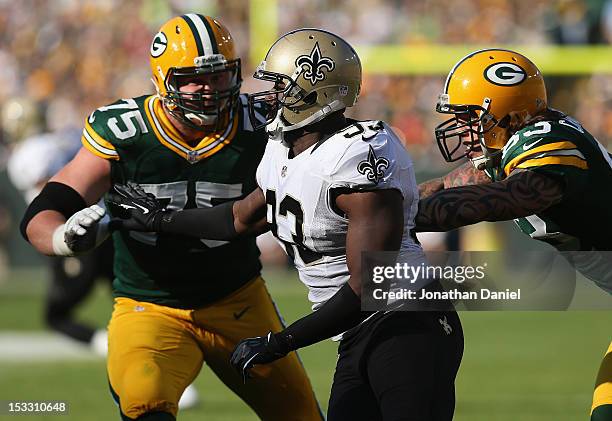 Junior Galette of the New Orleans Saints rushes against Tom Crabtree and Bryan Bulaga of the Green Bay Packers at Lambeau Field on September 30, 2012...