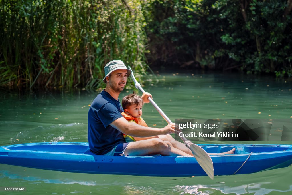 Un jeune père et son petit garçon font du kayak ensemble