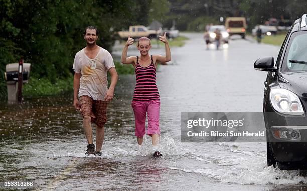 Gina Gibson gives a thumbs up as she and her husband, Richard, make their way down Saracennia Road in the Helena community in Jackson County,...