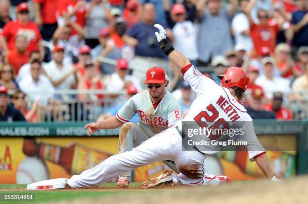 Jayson Werth of the Washington Nationals slides into third base for a triple in the third inning ahead of the tag by Kevin Frandsen of the...