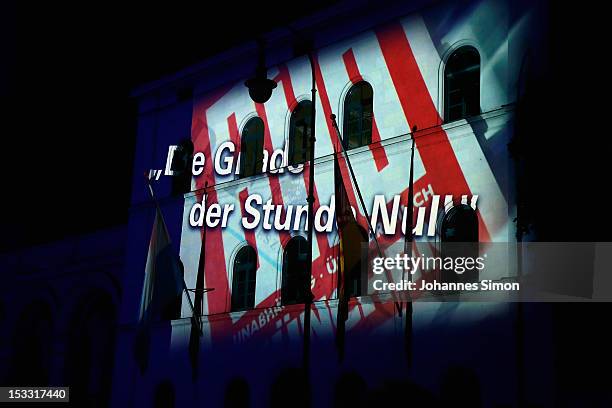 Projection is seen as revelers gather in the city center to watch the final laser show of German Unity Day on October 3, 2012 in Munich, Germany. The...