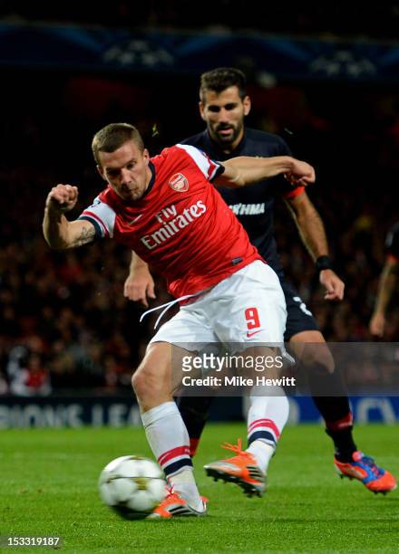 Lukas Podolski of Arsenal scores his team's second goal during the UEFA Champions League Group B match between Arsenal FC and Olympiacos FC at...