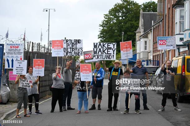 People protest over the proposed refugee barge, the Bibby Stockholm near Portland Port on July 11, 2023 in Portland, England. The port is expected to...