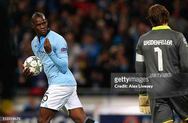 Mario Balotelli of Manchester City gestures to Roman Weidenfeller of Borussia Dortmund after scoring an equalising penalty kick during the UEFA...
