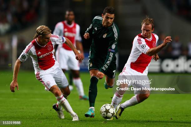 Christian Poulsen and Siem De Jong of Ajax tackle Cristiano Ronaldo of Real during the UEFA Champions League Group D match between Ajax Amsterdam and...