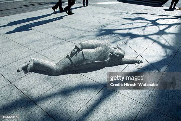 statue of an overworked businessman - japanese statue stockfoto's en -beelden